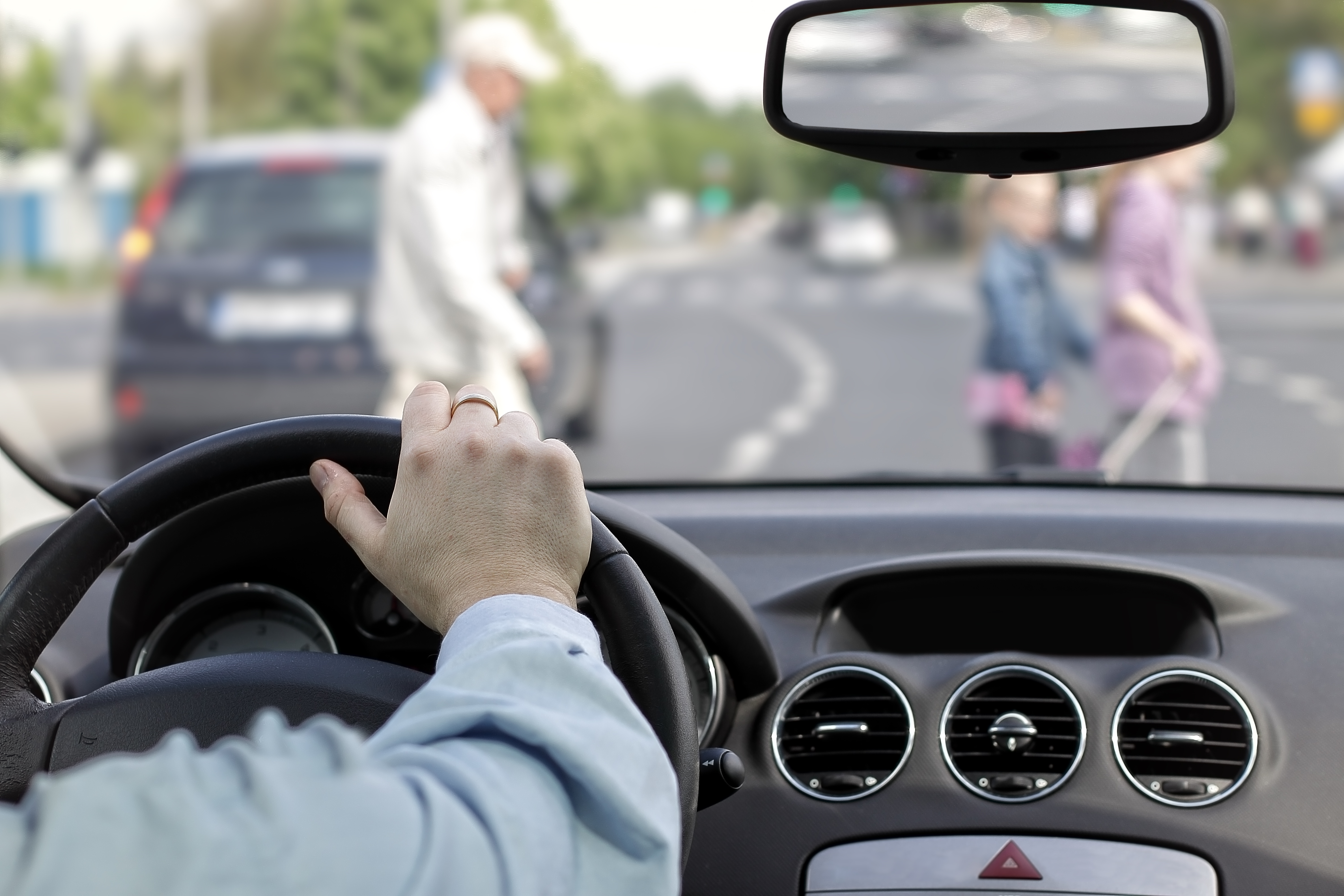 driver watching pedestrians cross street