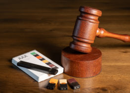 Juul E-Cigarette with cartridges next to gavel