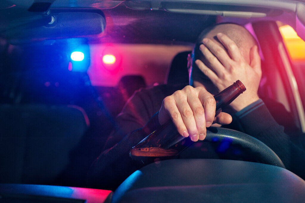 Man driving with beer bottle